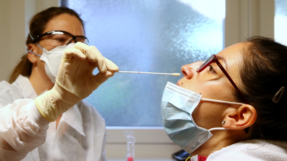 Joye takes a swab from a colleague at the Chene Medical Centre in Thierrens