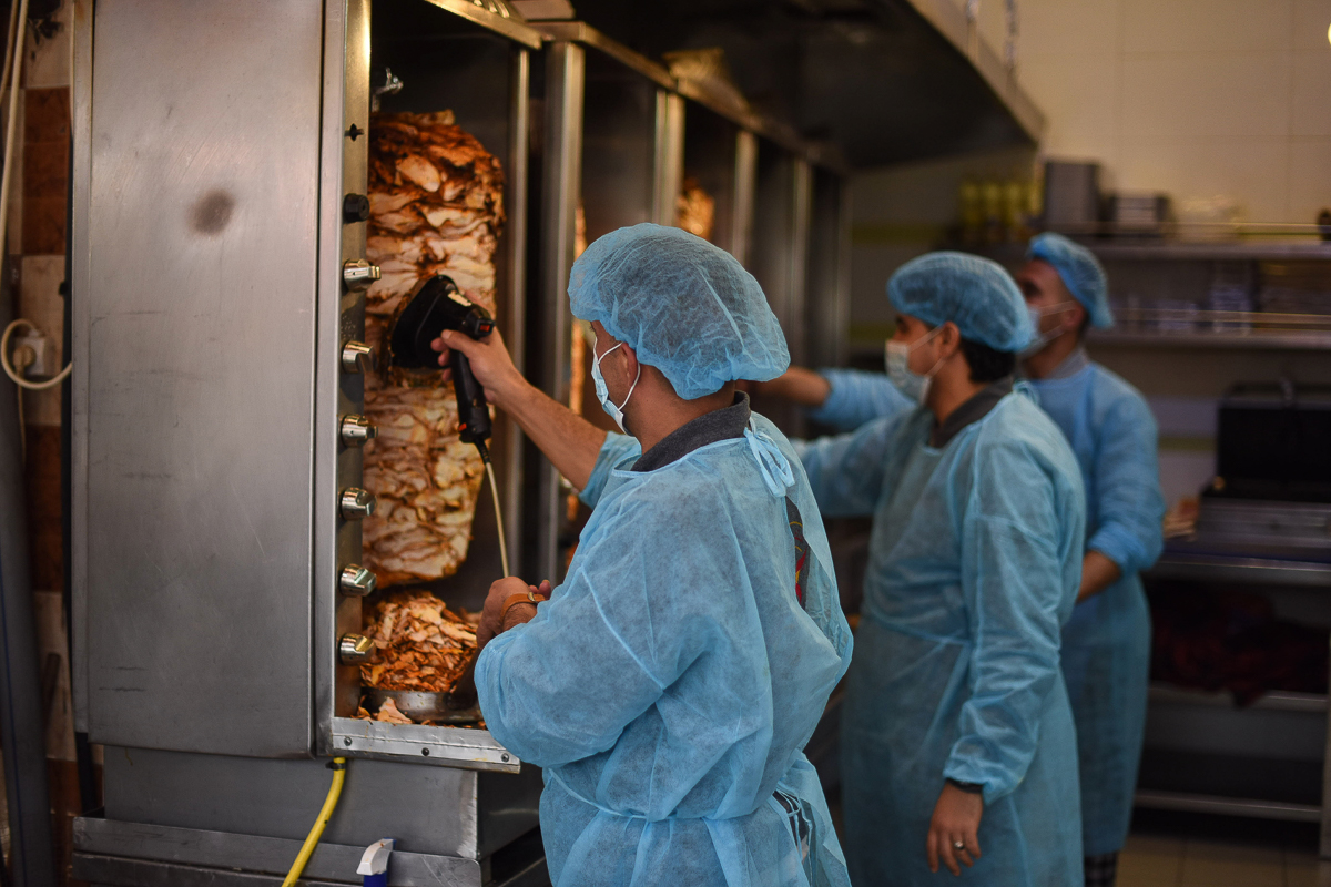 Workers at a shawarma shop wear protective clothing at work in Khan Yunis.