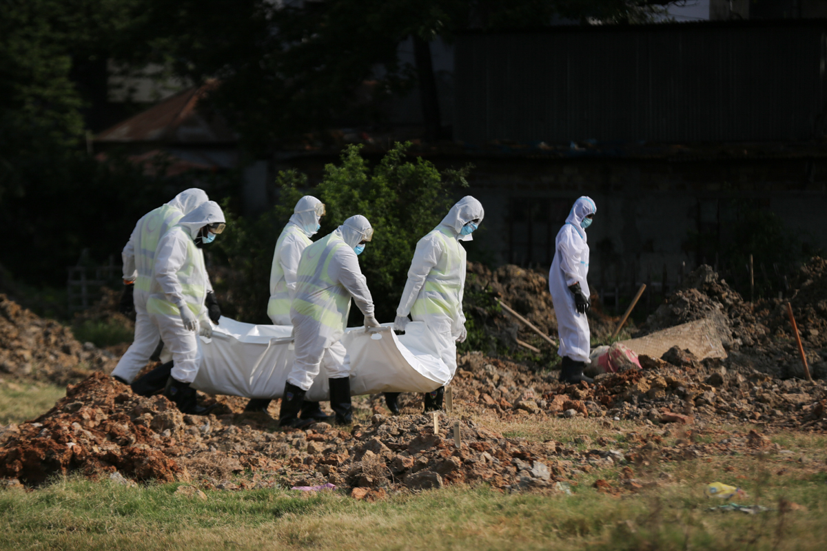 Volunteers of Al-Markazul Islami bury Covid-19 victim maintaining WHO guideline at Khilgaon-Taltola graveyard in Dhaka. Mahmud Hossain Opu/Al Jazeera