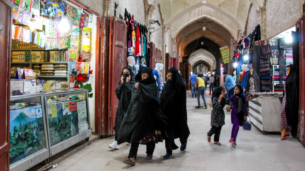IRAN-HEALTH-VIRUS Iranians, some wearing personal protective equipment, walk past shops in the southeastern city of Kerman on April 11, 2020, amid the coronavirus (COVID-19) pandemic. 