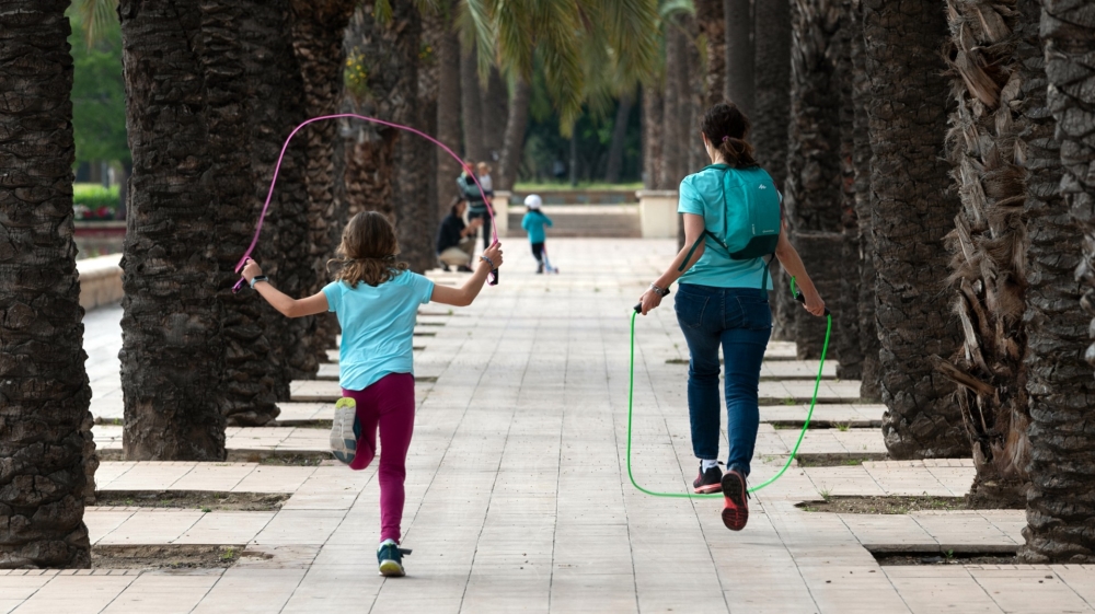 A woman jumps rope with a girl in Valencia, Spain