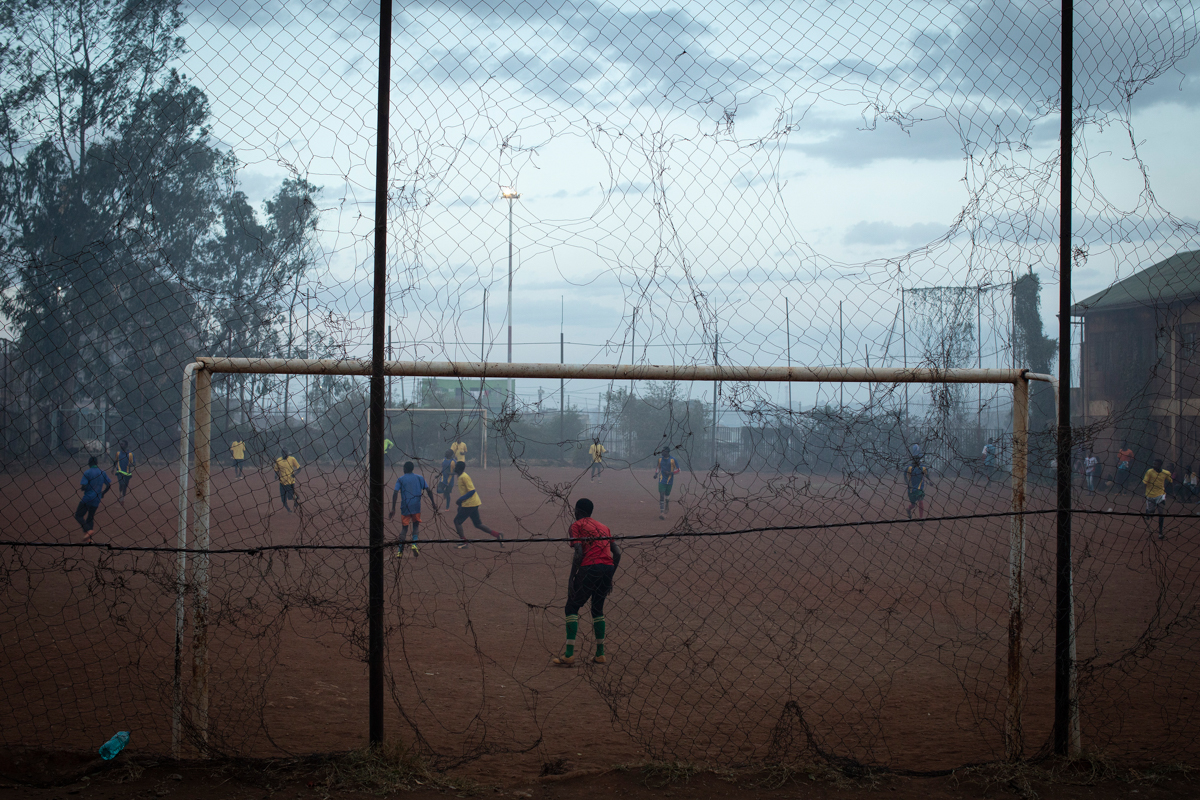 Young men play a football match in a pitch filled with smoke blowing from the Dandora dumpsite, in the slum of Korogocho in the capital Nairobi, Kenya, February 20, 2019. Nearly one million people liv