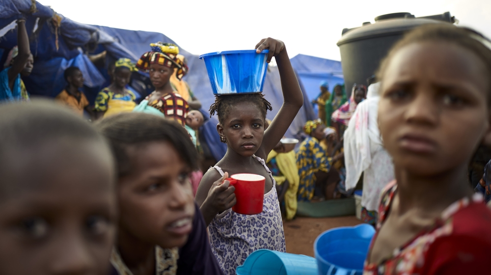 A Fulani girl woman holds a bowl of food on her head in an Internally Displaced People''s (IDP) camp in Faladie, where nearly 800 IDPs have found refuge after fleeing inter-communal violence in central