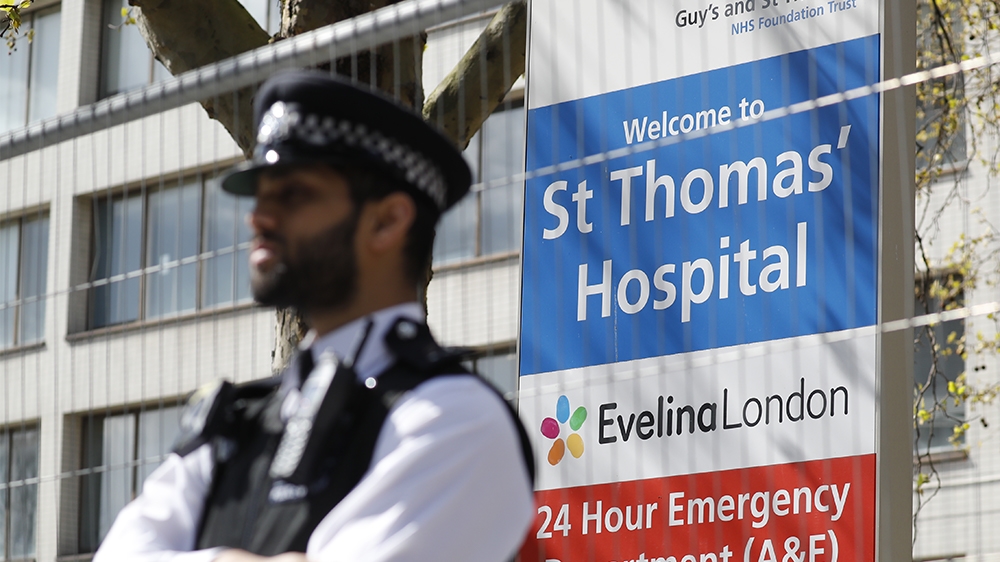 Police officers stand in front of barriers erected outside St Thomas' Hospital in London on April 6, 2020. - British Prime Minister Boris Johnson was in hospital on Monday undergoing tests after suffe