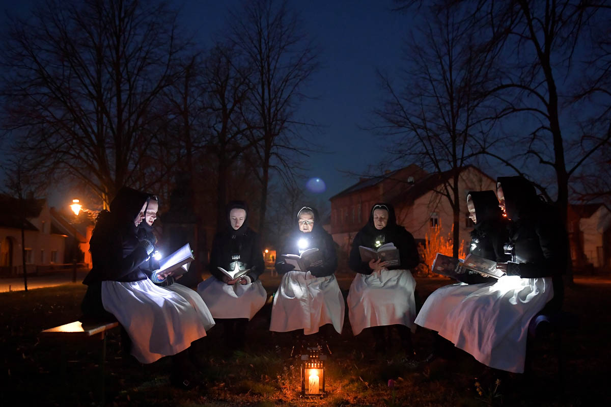 Women dressed in traditional clothes of the Slavic ethnic minority community of Sorbs meet early Easter Sunday to sing in front of a church in Schleife, eastern Germany, April 12, 2020, as the spread