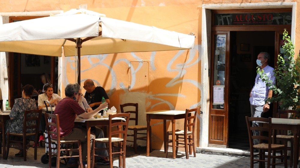 Sandro the owner of the Trattoria da Augusto in Trastevere stands at the door to observe the customers on May 19, 2020 in Rome, Italy. Museums, restaurants, bars, cafes, hairdressers