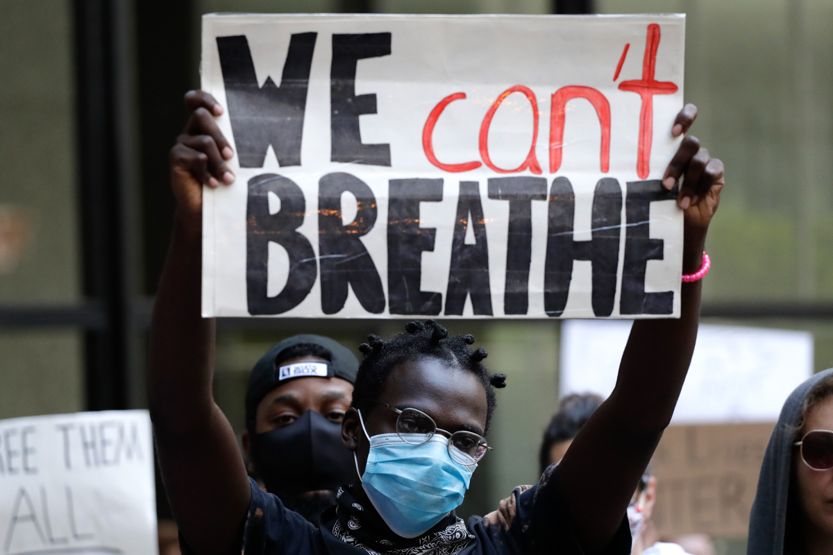 A peson holds sign during a protest over the death of George Floyd in Chicago, Saturday, May 30, 2020. Protests were held throughout the country over the death of George Floyd, a black man who died af
