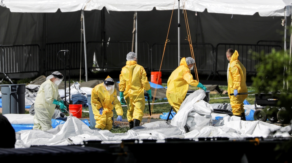 People in Personal Protective Equipment (P.P.E.) work to break down an area of The Samaritan''s Purse Emergency Field Hospital in Central Park during the outbreak of the coronavirus disease (COVID-19)