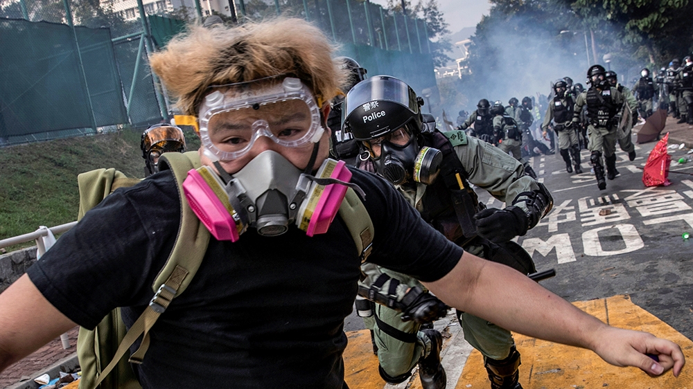 An anti-government protester, who later identified himself as a university student, is chased by riot policemen after skirmishes at the Chinese University of Hong Kong, in Hong Kong, China November 12