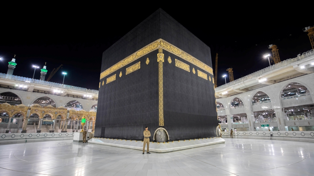 Saudi security officers stand in front of the Kaaba in an empty Grand Mosque, as a preventive measure against the coronavf Mecca