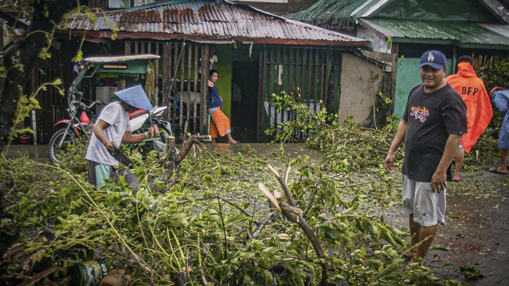 Citizens cut up a tree that has fallen on a road as Typhoon Vongfong makes landfall in the town of Can-avid, Eastern Samar province, the Philippines, 14 May 2020. The typhoon reached the Eastern Samar