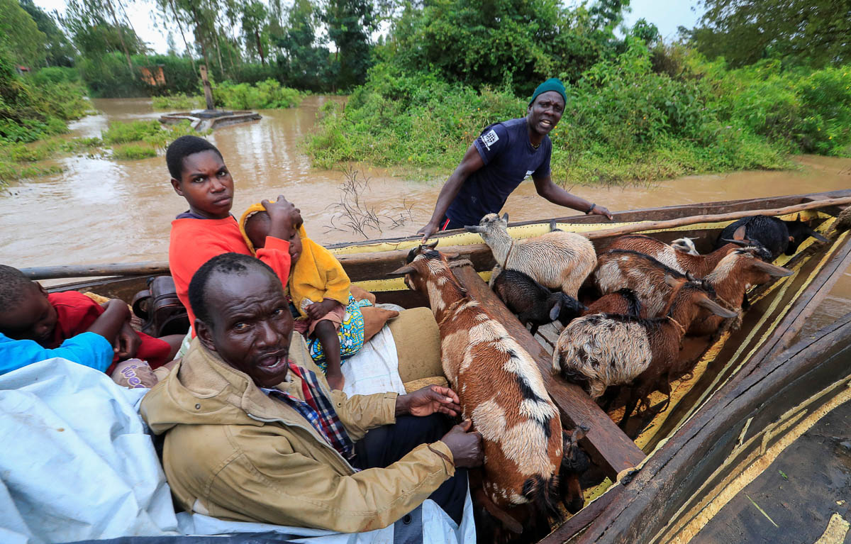 Residents use a boat to evacuate with their animals from the flood waters after River Nzoia burst its banks and due to the backflow from Lake Victoria, in Buyuku village of Budalangi, in Busia County,