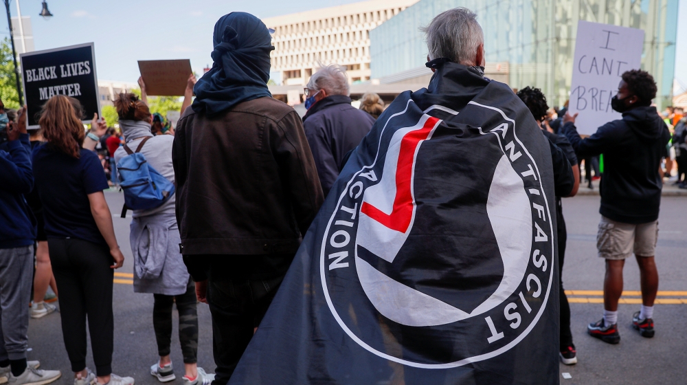 A protester carries an Antifascist Action flag at a rally following the death in Minneapolis police custody of George Floyd, in Boston, Massachusetts, U.S., May 31, 2020. REUTERS/Brian Snyder