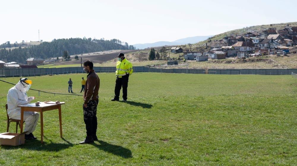 A member of the Slovak military tests a Roma people for the new coronavirus COVID-19 outside of the Roma settlement in the eastern Slovakian village of Janovce, Slovakia on April 11, 2020