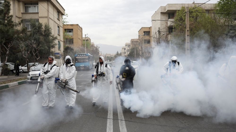 Members of firefighters wear protective face masks, amid fear of coronavirus disease, as they disinfect the streets, ahead of the Iranian New Year Nowruz, March 20, in Tehran