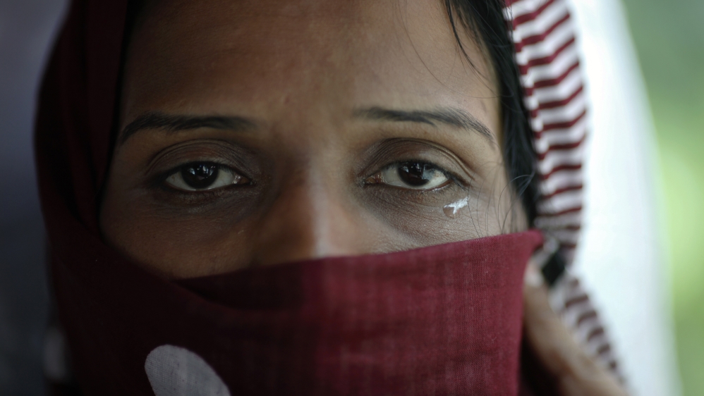 A Pakistani refugee, a member of the Ahmadiyya, an Islamic minority sect, cries as she leaves a detention centre with her family on a bus in Bangkok