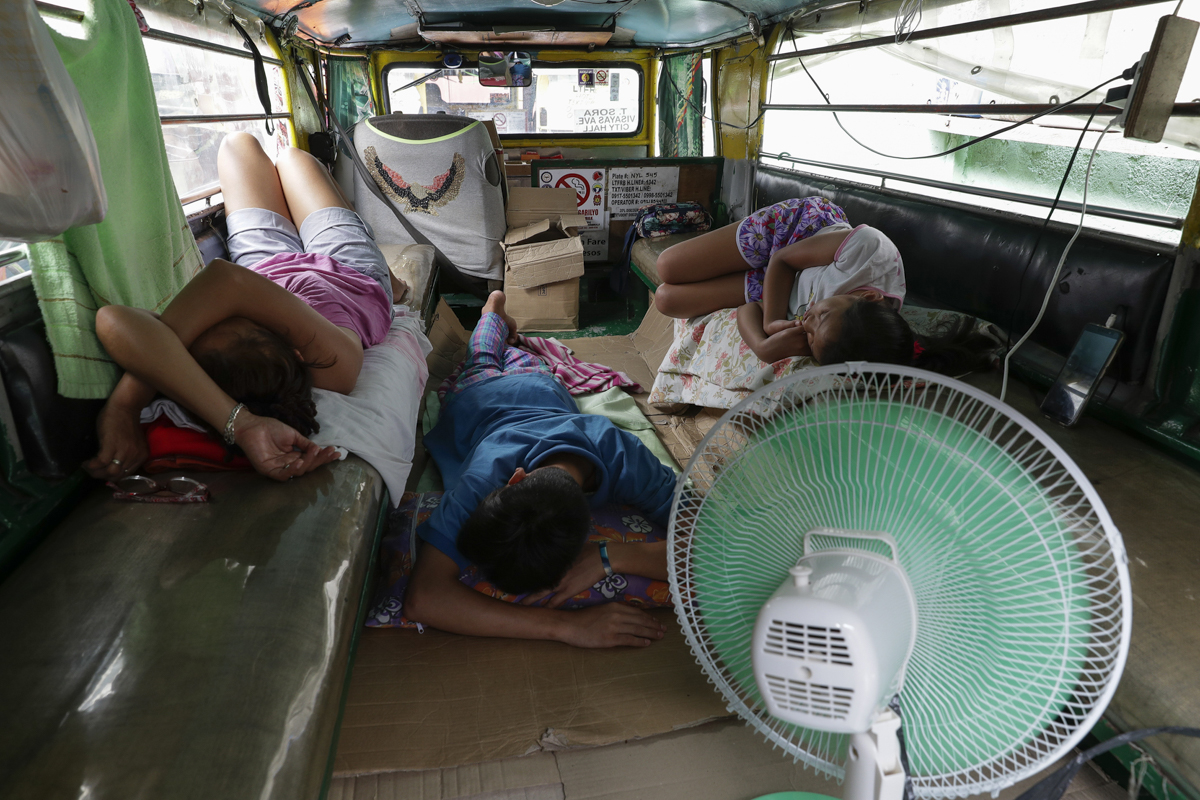 The Recio family sleeps inside their passenger jeepney at a terminal which have been home for them on Wednesday, June 17, 2020 in Quezon city, Philippines. About 35 jeepney drivers were forced to stay