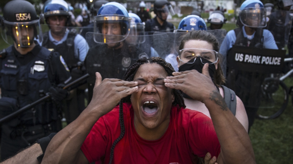 WASHINGTON, DC - JUNE 22: A woman reacts to being hit with pepper spray as protesters clash with U.S. Park Police after they attempted to pull down the statue of Andrew Jackson in Lafayette Square nea