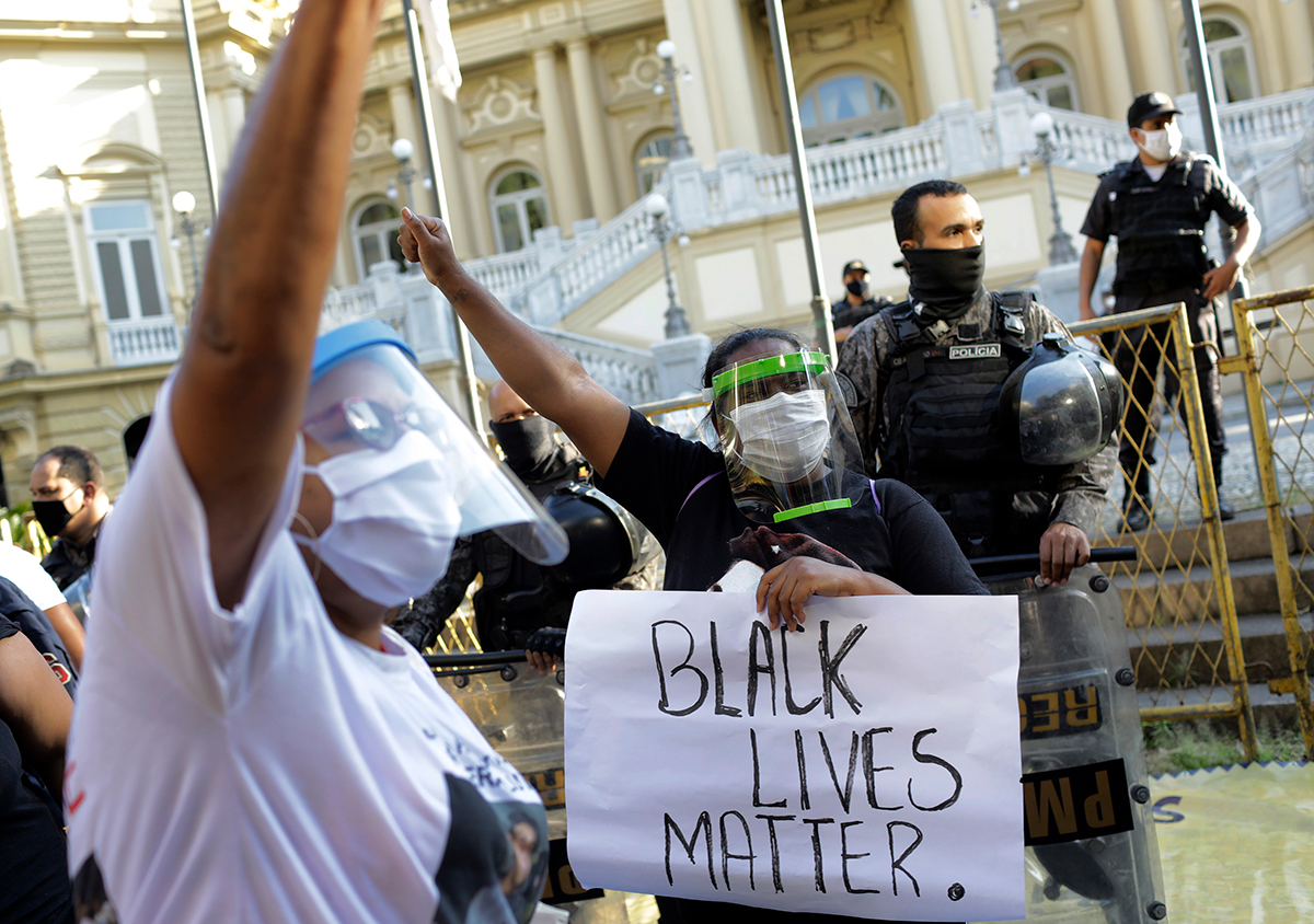 Women wearing face shields against the spread of the new coronavirus, protest against crimes committed by the police against black people in the favelas, outside the Rio de Janeiro''s state government,