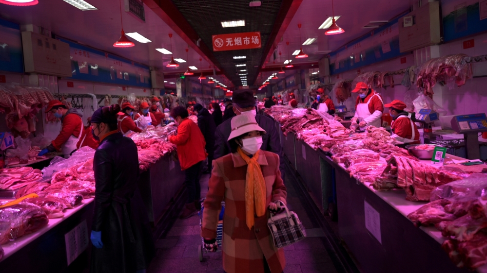 FILE PHOTO: Customers wearing face masks buy pork meat at the Xinfadi wholesale market, as the country is hit by an outbreak of the novel coronavirus disease (COVID-19), in Beijing