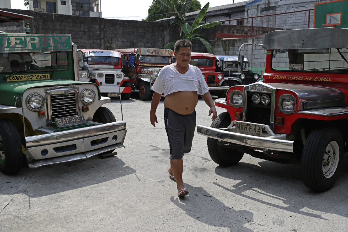 Driver Jude Recio walks past jeepneys parked at the Tandang Sora terminal which have been home for them since a lockdown started three months ago, on Wednesday, June 17, 2020 in Quezon city, Philippin
