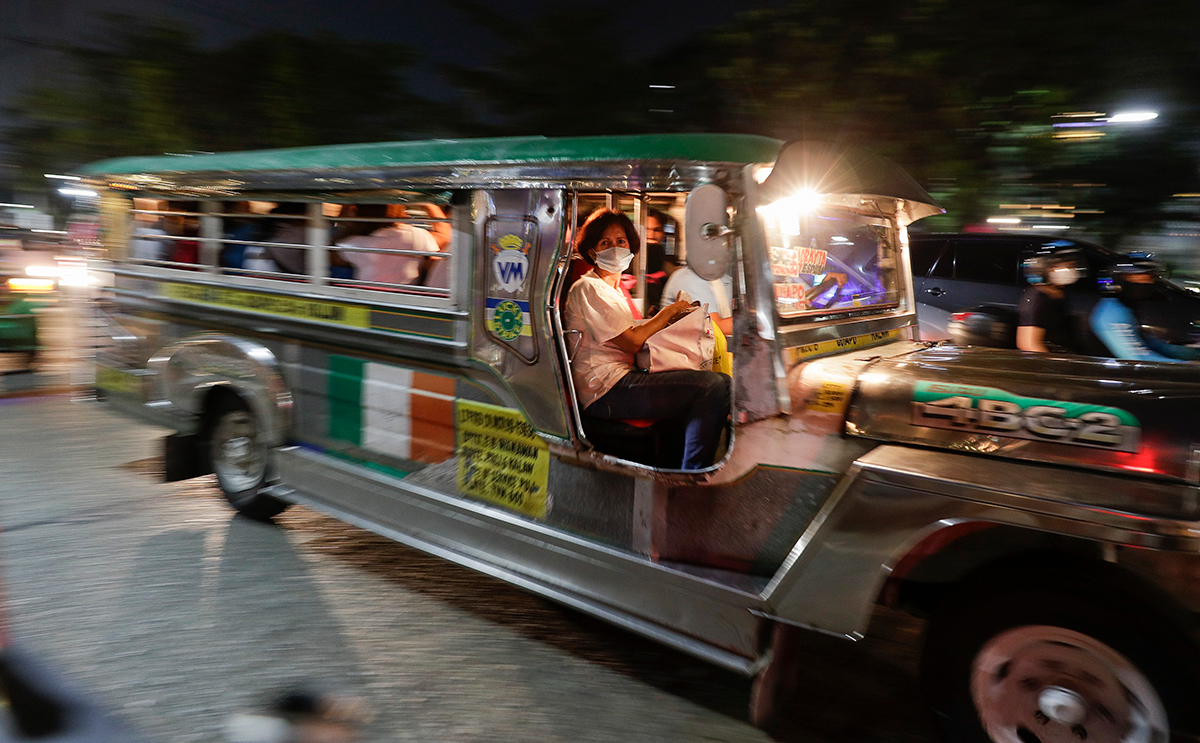 A woman wears a protective mask as she rides a passenger jeepney in Manila, Philippines on Tuesday, March 10, 2020. For most people, the new coronavirus causes only mild or moderate symptoms, such as