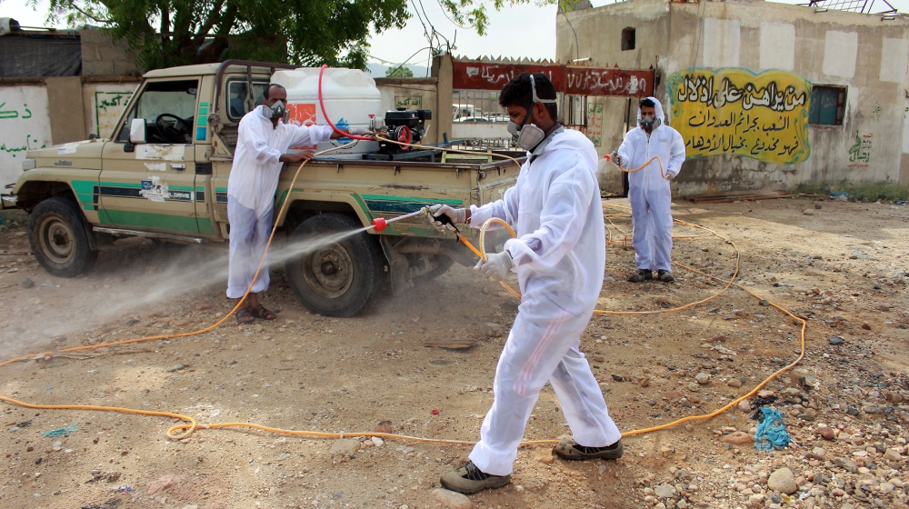 Yemeni sanitation workers, wearing protective gear, spray disinfectant in a neighbourhood in the northern Hajjah province on May 31, 2020, during the ongoing coronavirus pandemic. ESSA AHMED / AFP
