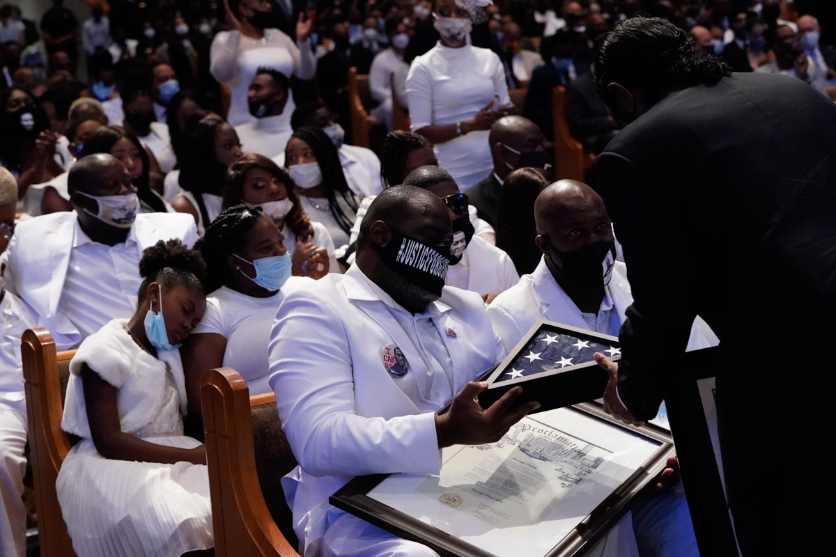 epa08475607 Congressman Al Green hands the family a flag during the funeral service for George Floyd at the Fountain of Praise church, Houston, Texas, USA, 09 June 2020. A bystander''s video posted onl