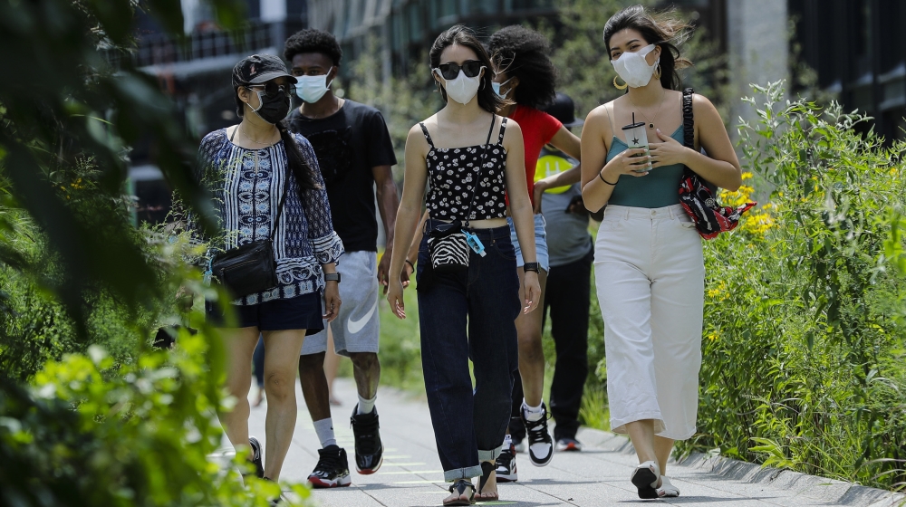 People wearing protective masks during the coronavirus pandemicwalk along the High Line Park, Thursday, July 16, 2020, in New York. The Highline opened today after having been closed the last few mont