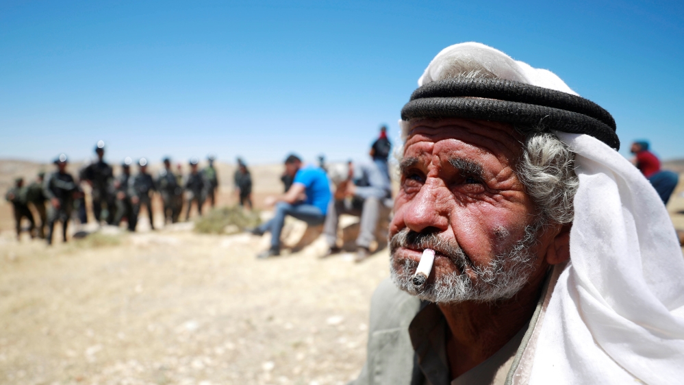 Palestinian man smokes a cigarette during a protest in the Israeli-occupied West Bank