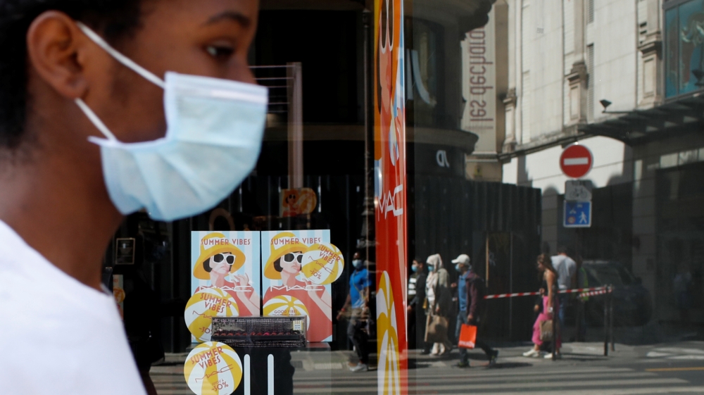 People, wearing protective face masks, walk in a street in Paris as France enforces mask-wearing in enclosed public spaces as part of efforts to curb a resurgence of the coronavirus disease (COVID-19) across the country