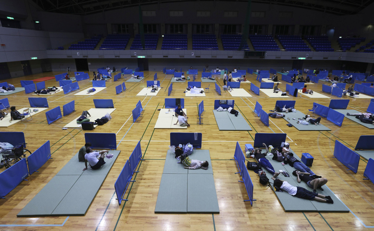 Local residents practice social distancing amid the coronavirus disease (COVID-19) outbreak as they rest in the evacuation centre for the affected by the flooded area caused by heavy rain along Kuma R
