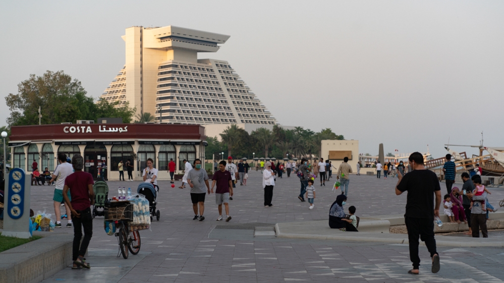 People walk on Doha's corniche as Qatar enters phase two of easing coronavirus restriction [Sorin Furcoi/Al Jazeera]
