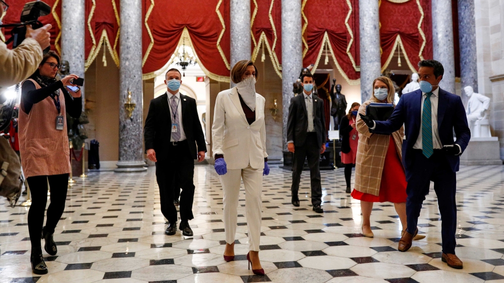 US Speaker of the House Nancy Pelosi wears a face mask while walking to the House Chamber before a vote on an additional economic stimulus package, on Capitol Hill in Washington, US