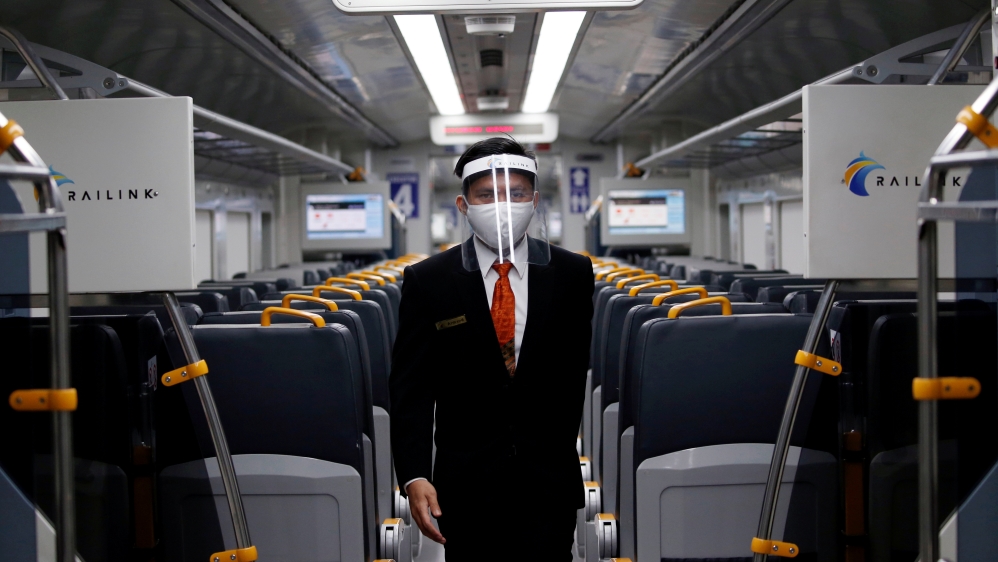 An employee wearing a protective mask and face shield walks inside a Railink train following the coronavirus disease (COVID-19) outbreak in Jakarta