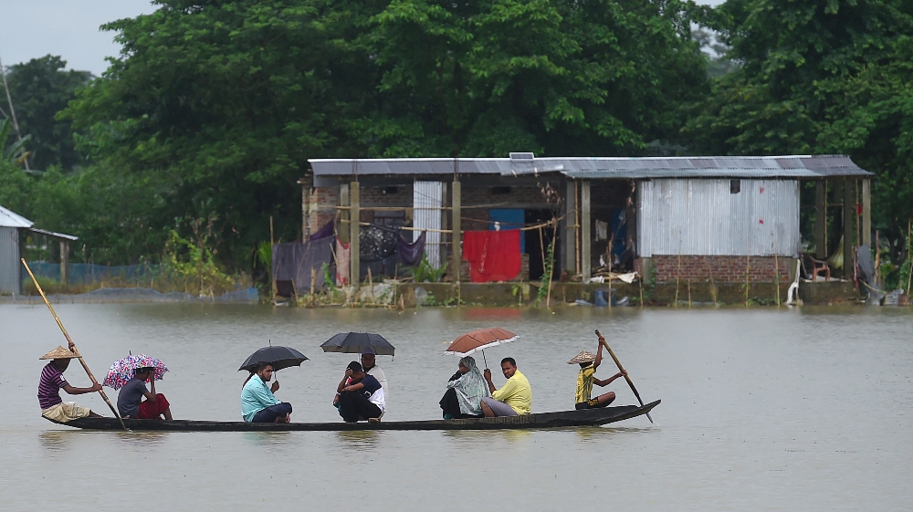 BANGLADESH-INDIA-NEPAL-WEATHER-FLOOD People ride on a boat through flooded waters in Sunamgong on July 14, 2020. Almost four million people have been hit by monsoon floods in South Asia
