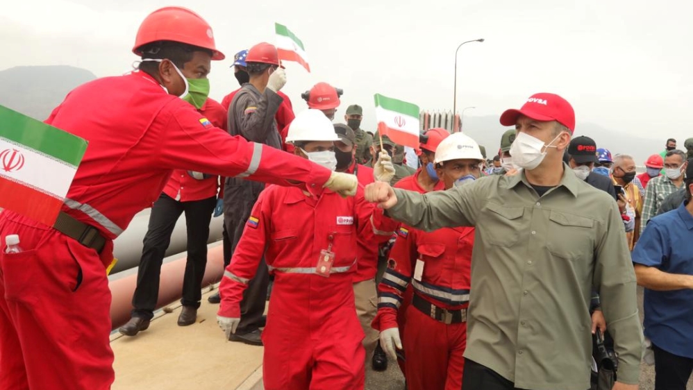 A worker of the state-oil company Pdvsa greets Venezuela's Oil Minister Tarek El Aissami during the arrival of the Iranian tanker ship