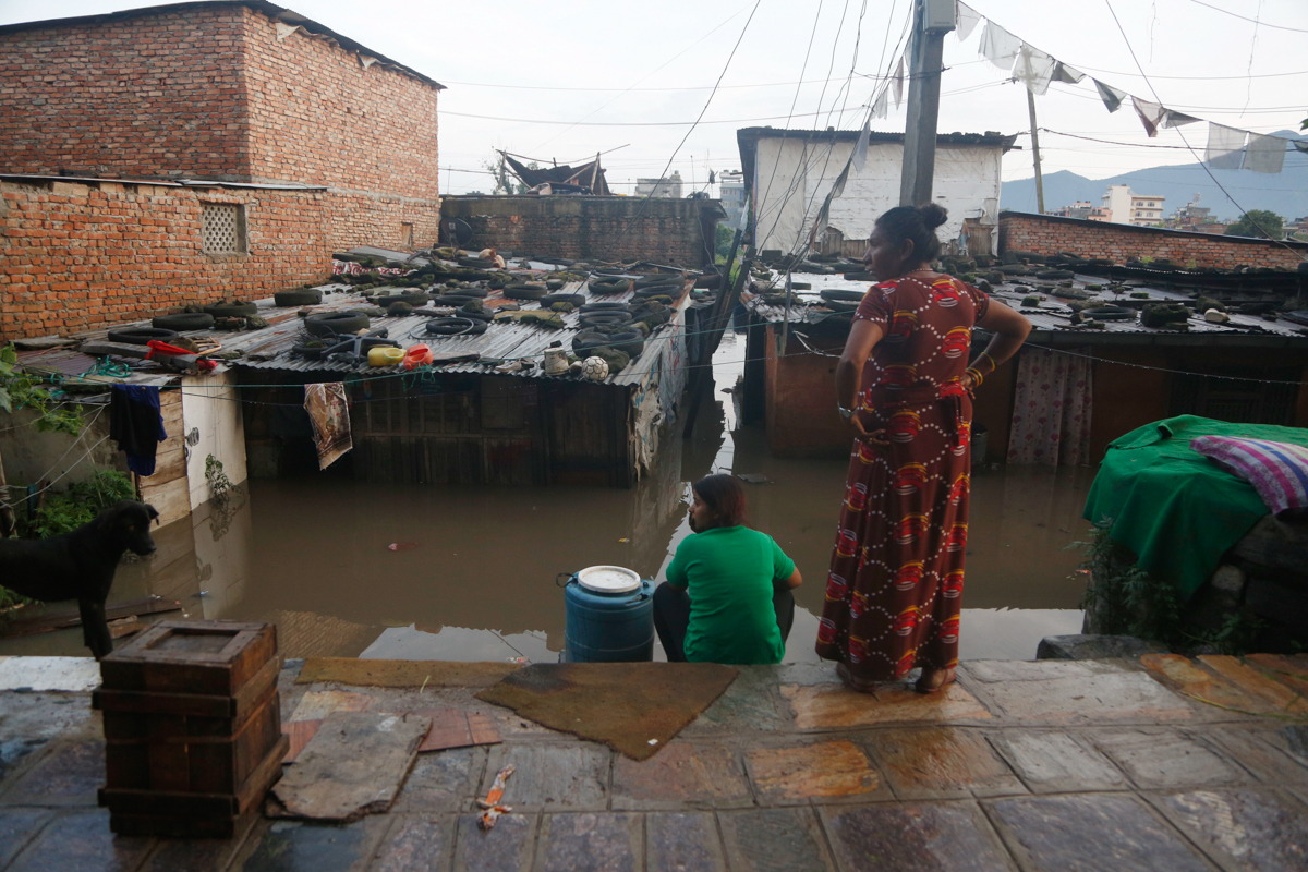 Nepalese people sit outside their flooded house on the bank of Bagmati river following heavy monsoon rains in Kathmandu, Nepal, Monday, July 20, 2020. The weather department has has forecast heavy rai