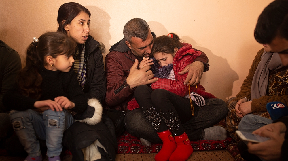 In this Feb. 12, 2020 photo, Malak Saad Dakhel, an 11 year-old Yazidi, is overwhelmed by journalists and well-wishers as her family tries to comfort her after her escape from Syria, in Sharia, Iraq. S