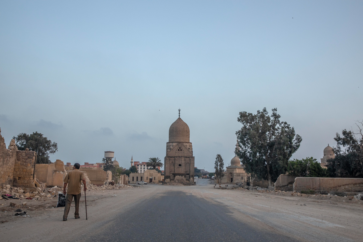 A man looks at graves partially demolished to make way for a new highway through the Northern Cemetery in Cairo, Egypt, Wednesday, July 29, 2020. In the center is the 500-year-old domed tomb of a Maml