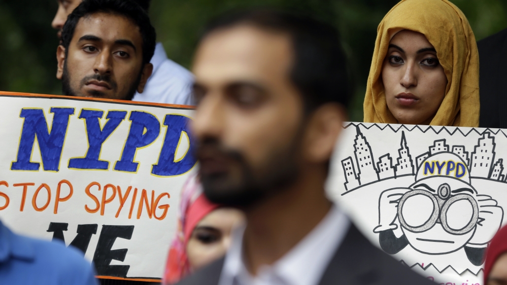 People hold signs while attending a rally to protest New York Police Department surveillance