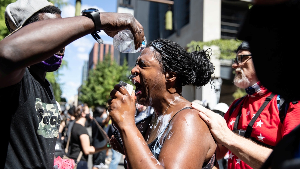 A woman is doused with water as she speaks during a protest against racial injustice in Portland, Oregon, U.S., August 22, 2020. REUTERS/Maranie Staab