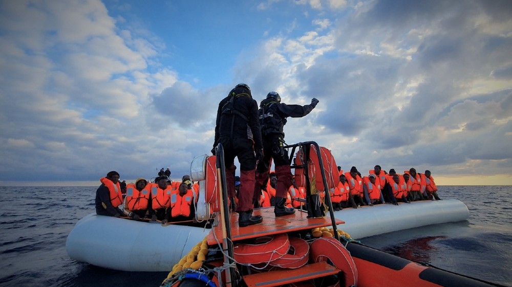 Migrants wearing lifejackets on a rubber dinghy are pictured during a rescue operation by the MSF-SOS Mediterranee run Ocean Viking rescue ship, off the coast of Libya in the Mediterranean