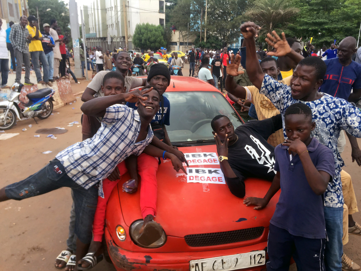 Opposition supporters react to the news of a possible mutiny of soldiers in the military base in Kati, outside the capital Bamako, at Independence Square in Bamako, Mali August 18, 2020. REUTERS/Rey B