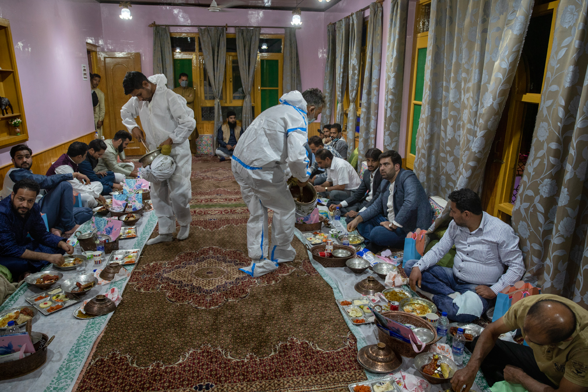 Kashmiri Wazas, or chefs, in personal protective equipment serve Wazwan during a wedding ceremony on outskirts of Srinagar, Indian controlled Kashmir, Tuesday, Sept. 15, 2020. The coronavirus pandemic