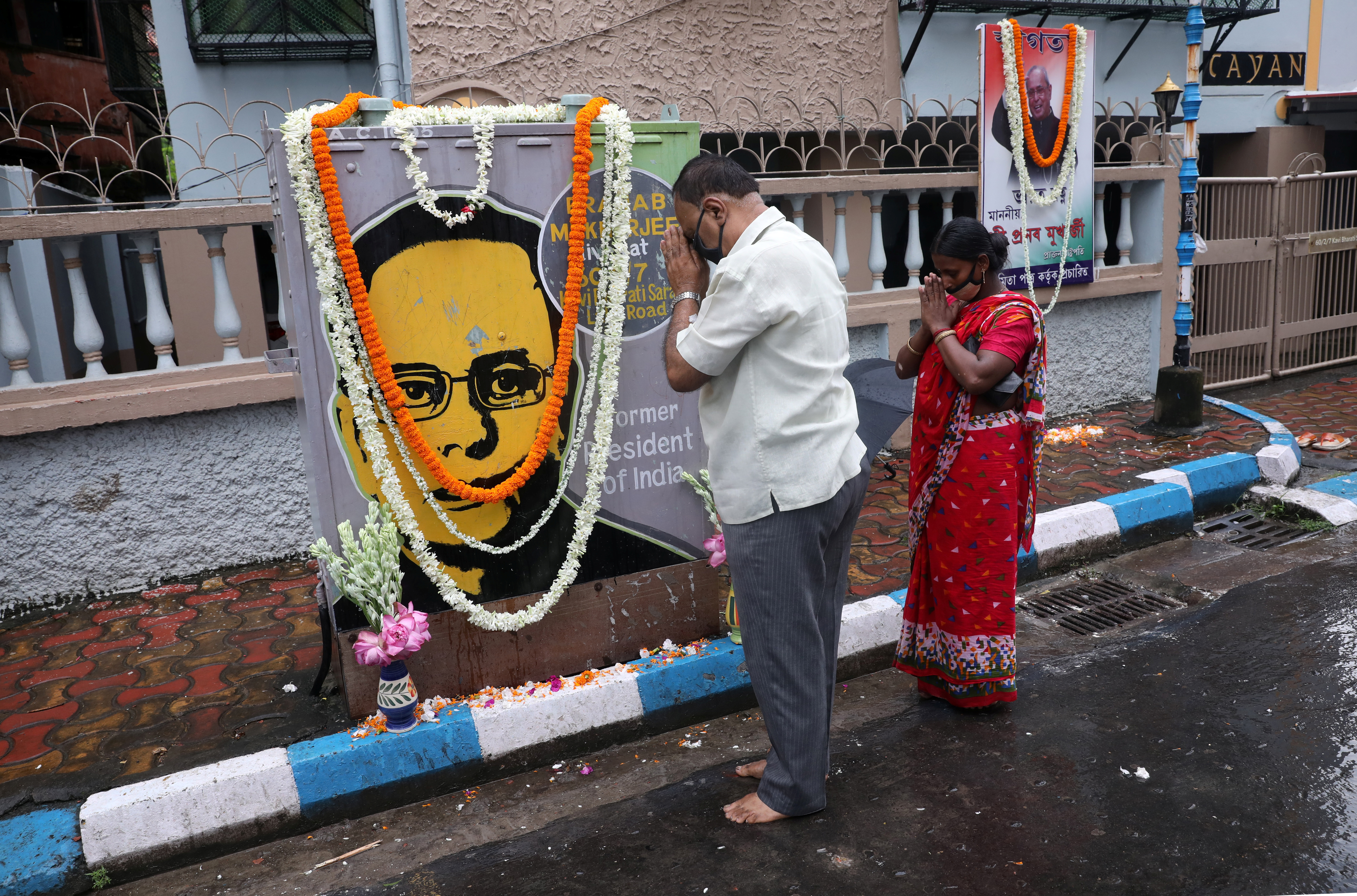 People pray in front of a painting of India's former President Pranab Mukherjee, in Kolkata, September 1, 2020 [File: Rupak De Chowdhuri/Reuters]