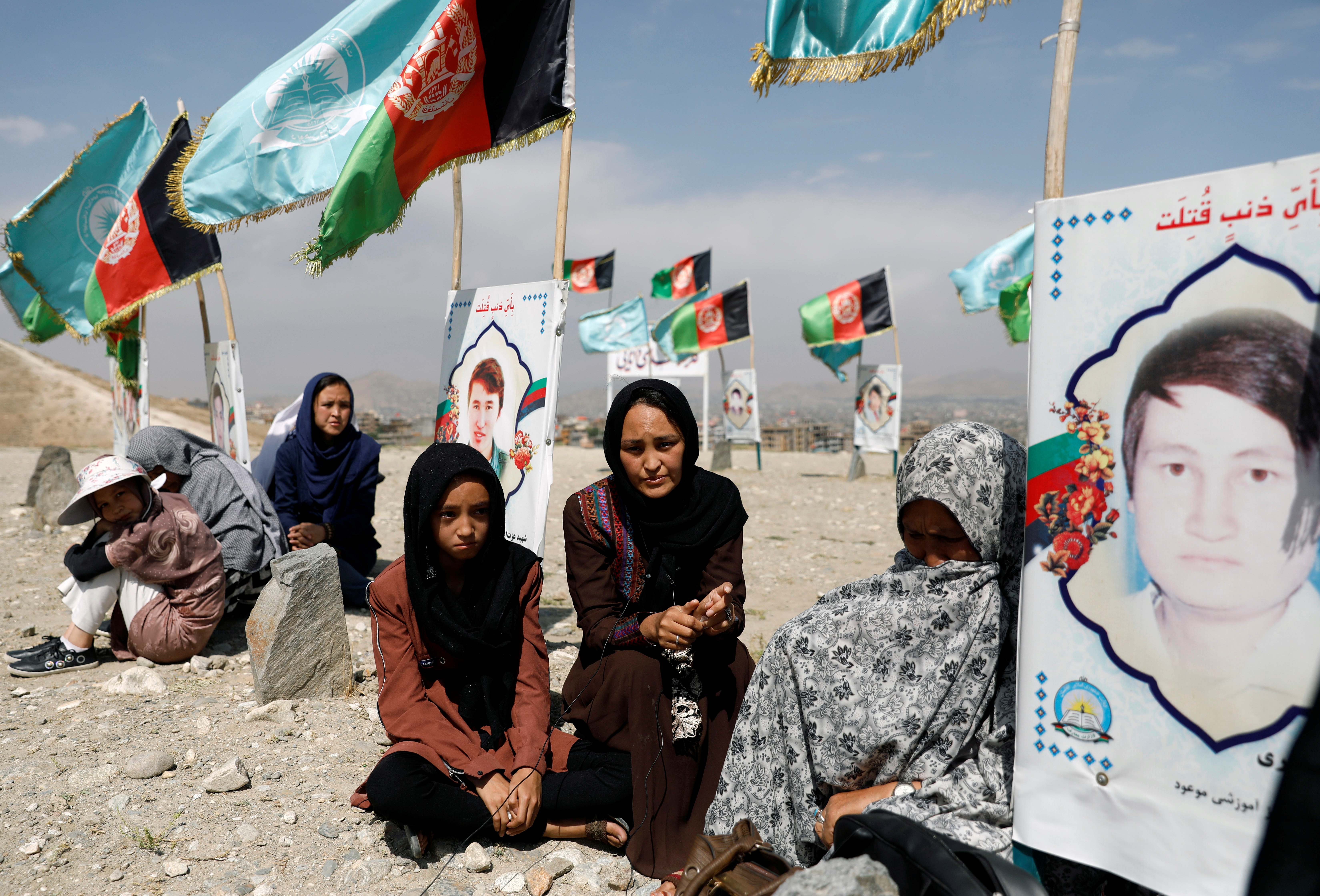 Relatives gather at a graveyard of the victims who were killed in a suicide attack in an educational centre two years ago, as Afghan government officials and the Taliban hold talks in Doha aimed at ending 19 years of war in the country, in Kabul, Afghanistan September 14, 2020 [Mohammad Ismail/Reuters]