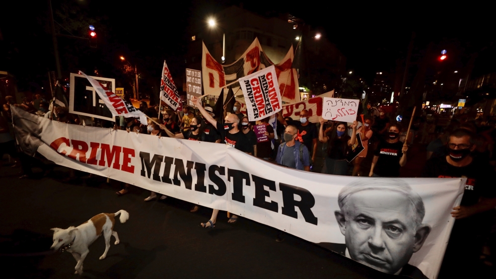 Israeli protesters hold signs and chant slogans during a demonstration against Israeli Prime Minister Benjamin Netanyahu In Tel Aviv, Israel, Thursday, Aug. 27, 2020
