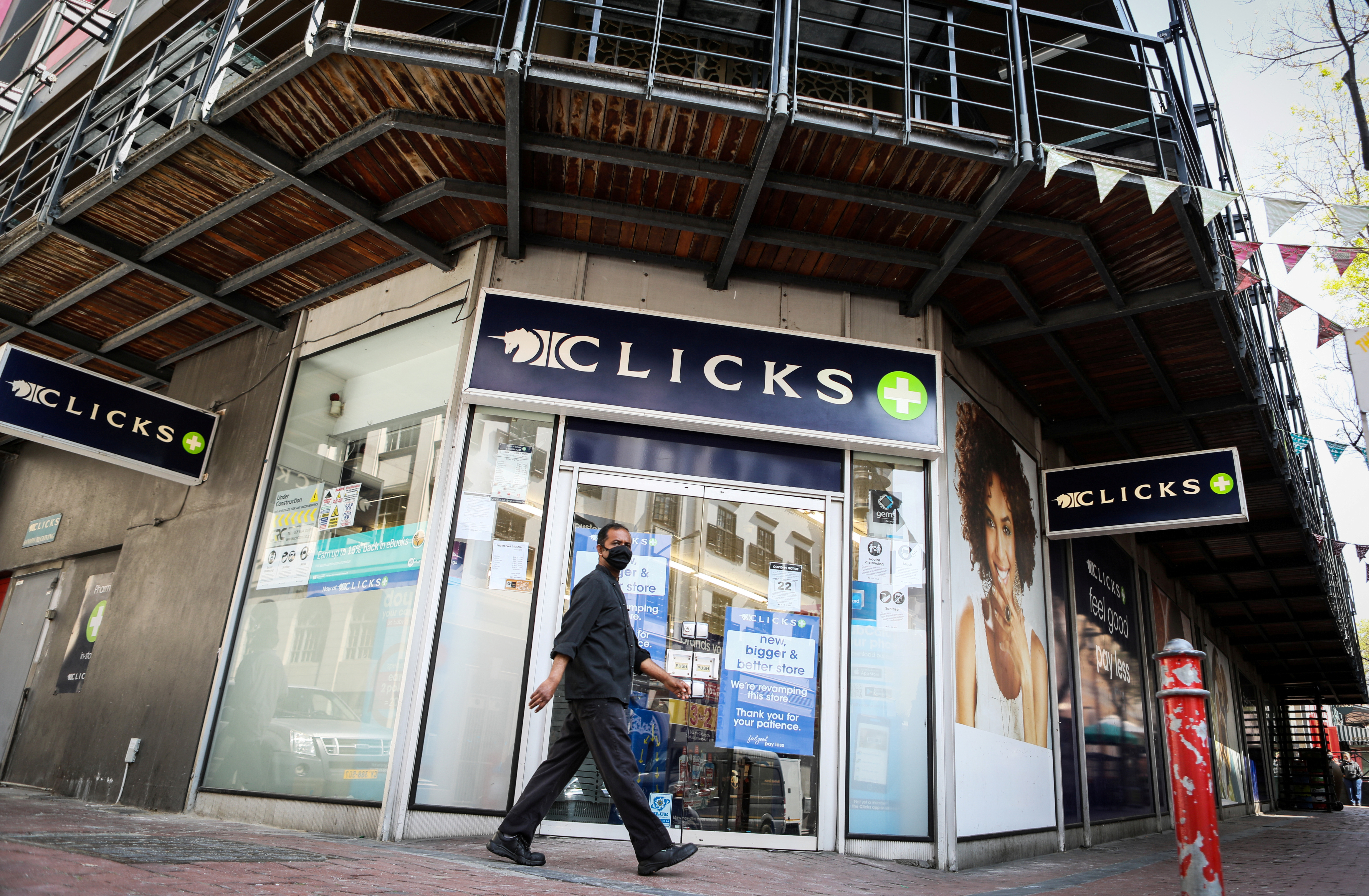 A man walks past a closed branch of Clicks after protests over an advertisement on its website in September [File: Reuters]