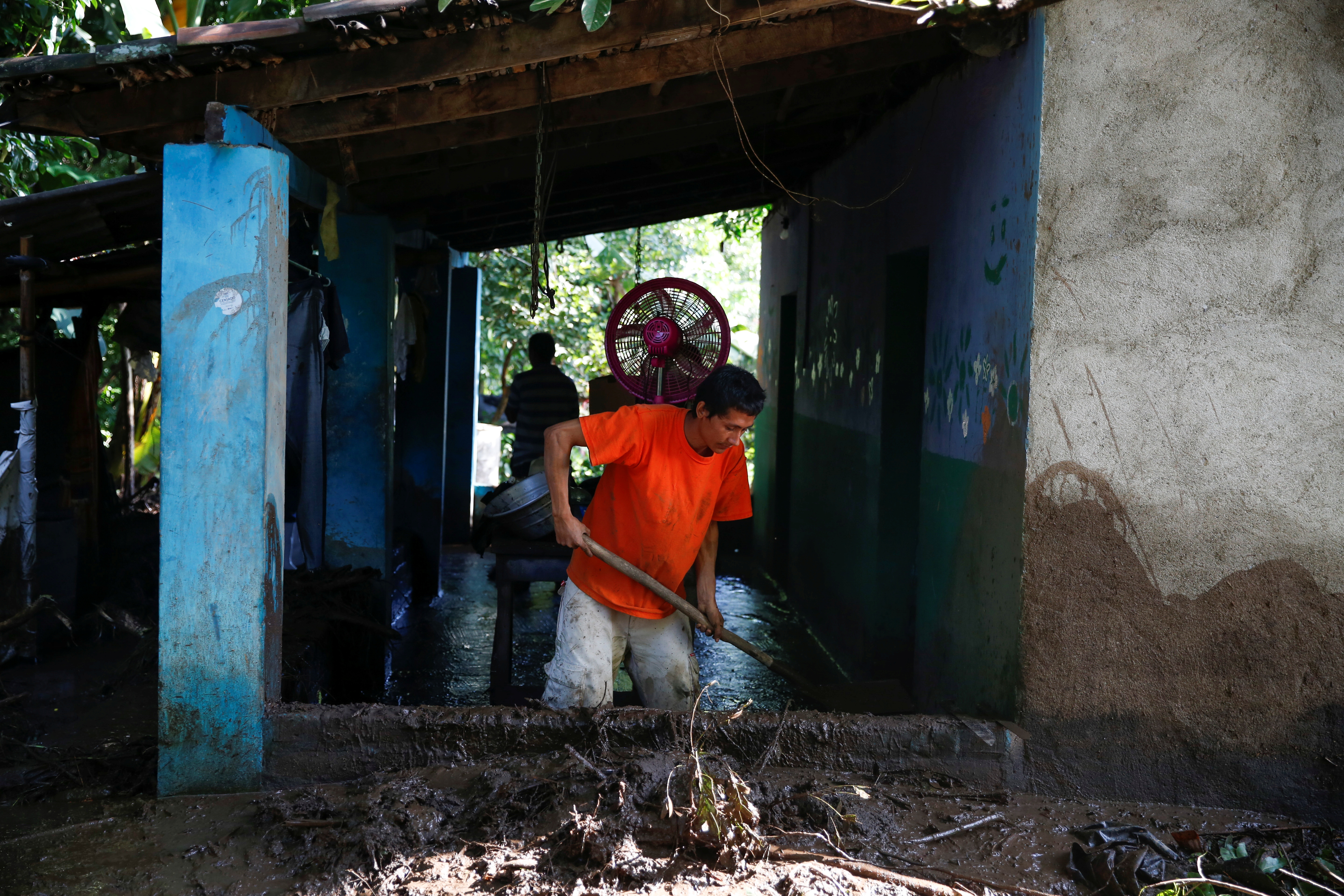 A man clears the mud at the site of the landslide sparked by heavy rains in Los Angelitos village on October 30
